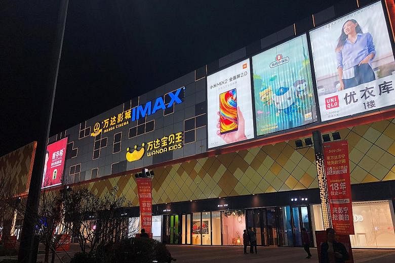 Advertisements on the facade of Wanda Plaza, owned by Dalian Wanda Group, in Xinxiang, Henan province. Retail sales in Xinxiang soared 12 per cent last year, exceeding Beijing's growth of 5.2 per cent.