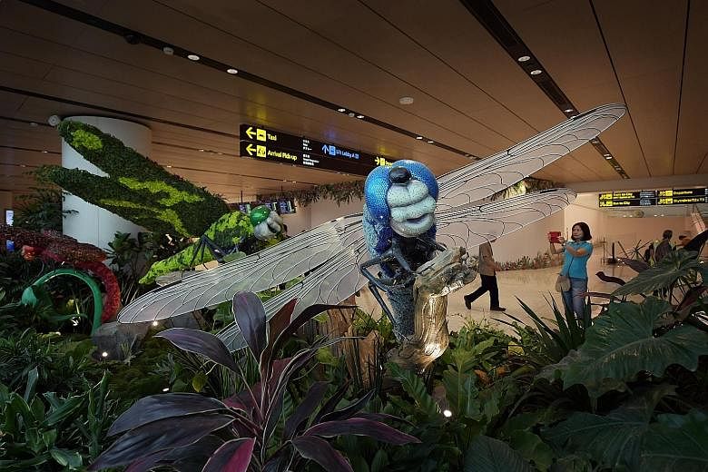 The new 460 sq m garden at Changi Airport Terminal 1's arrival hall, which opened on Tuesday. Featuring palm trees, dragonfly topiaries and sculptures, as well as a pond, the garden is the airport's first in a public area.