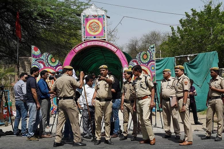 Indian policemen stand guard outside the ashram of controversial Indian guru Asaram Bapu (above) in New Delhi yesterday. Asaram, who has millions of followers, was yesterday jailed for life by a court in Jodhpur, for raping a teenage devotee on the p