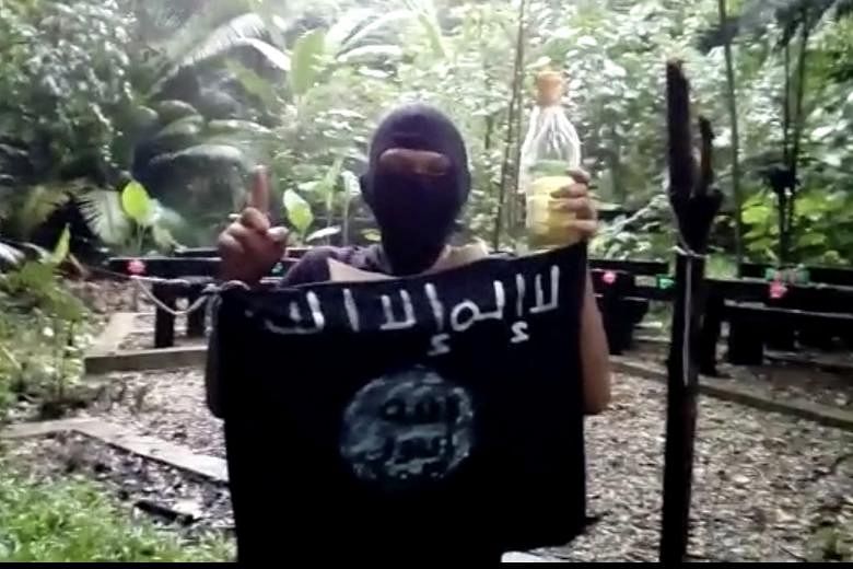 The video of the black-clad youth holding an ISIS flag and a Molotov cocktail is believed to have been recorded in a secluded area.