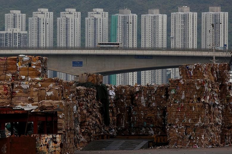 Tonnes of waste paper at a Hong Kong dock on Sept 15 waiting to be shipped to mainland China. The 24 types of waste banned from being brought in this year include scrap plastic and paper, which are processed and recycled into raw materials used to ma