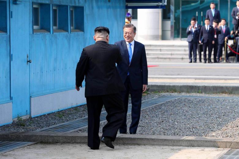 North Korea's leader Kim Jong Un (left) shakes with South Korea's President Moon Jae In at the Military Demarcation Line that divides their countries at Panmunjom, on April 27, 2018.
