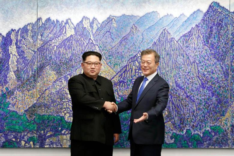 South Korea's President Moon Jae in (left) shakes hands with North Korea's leader Kim Jong Un during the Inter-Korean summit in the Peace House building on the southern side of the truce village of Panmunjom, on April 27, 2018.