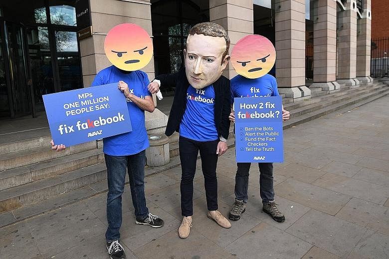 A protester wearing a mask depicting Facebook's CEO Mark Zuckerberg is flanked by two others wearing angry emoji masks during a demonstration in London on Thursday. The social media company this week finally released the internal rules that its moder