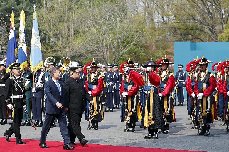 South Korean President Moon Jae In and North Korean leader Kim Jong Un inspecting the guard of honour at the Peace House in the truce village of Panmunjom in the South yesterday. Mr Moon quipped that Mr Kim could see a better performance if he visite