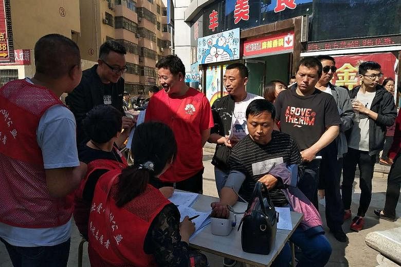 People lining up yesterday to donate blood to victims of a knife attack at a school in Mizhi county, Shaanxi province, China. Nine children were killed and 10 others hurt in Friday's incident.