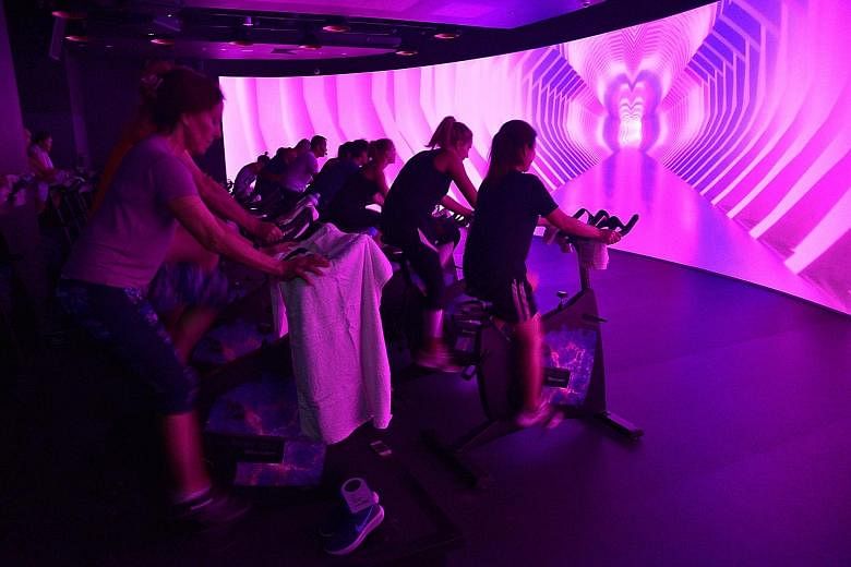 Participants getting into the groove of VR cycling, which uses technology to change the whole workout experience.