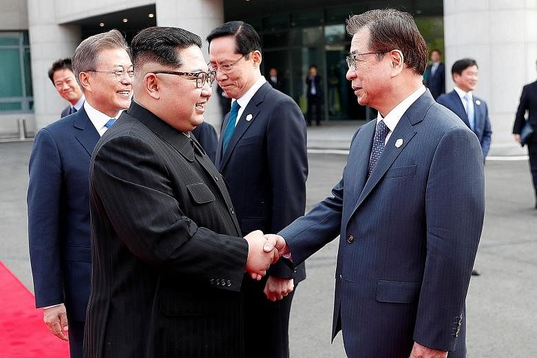 Mr Kim Jong Un (left) shaking hands with Mr Suh Hoon, South Korea's chief of the National Intelligence Service, at the truce village of Panmunjom, inside the demilitarised zone separating the two Koreas, last Friday. Mr Suh was one of the first South