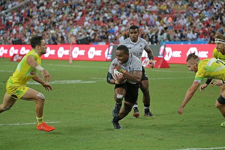 Top: Fiji's Waisea Nacuqu, the Man of the Match, sprinting towards a try. Fiji beat Australia with a late converted try - the third different team to earn the title in Singapore since the series returned in 2016. Above: Fiji players greeting their de