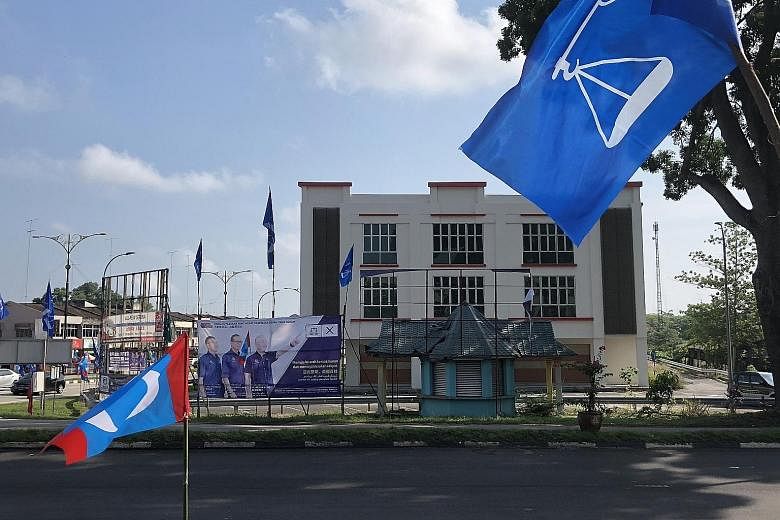 Left: The opposition billboard in Yong Peng, Johor, showing BN's Dr Wee Ka Siong with Prime Minister Najib Razak and his wife, and the empty space after the EC removed it. Above: Opposition candidate Liew Chin Tong in front of a BN poster of Transpor