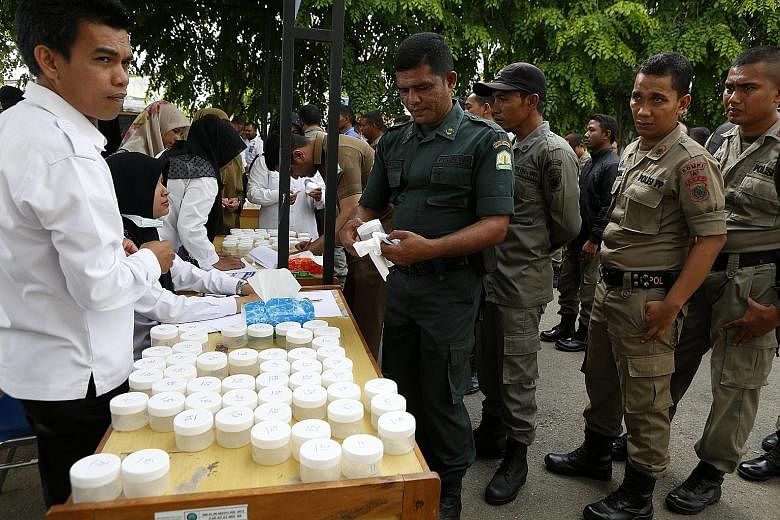Hundreds of officers from Aceh's syariah and municipal police force queueing up to undergo a drug test at the National Narcotics Agency in Banda Aceh, Indonesia, yesterday. Indonesian President Joko Widodo is urging an increase in efforts to fight il