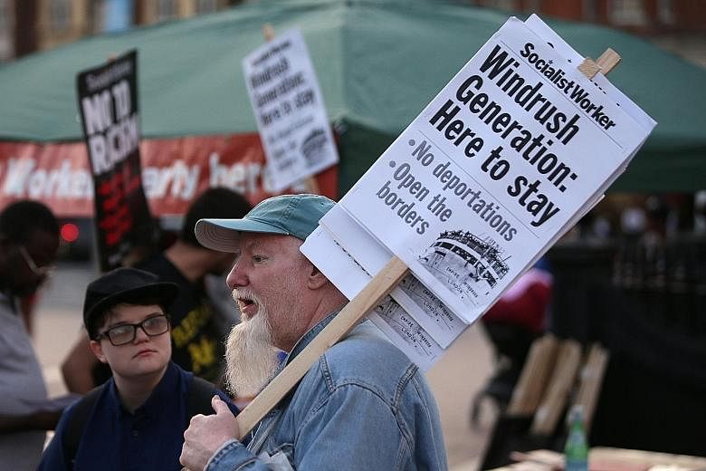 Protesters carrying placards in support of the Windrush generation at a rally in London last month. Though the Caribbean migrants have a legal right to remain in Britain, some have been targeted by immigration laws.