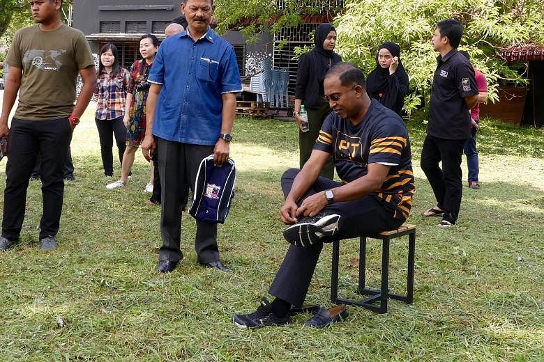 Perak Menteri Besar Zambry Abdul Kadir lacing up his shoes in preparation for a campaign video shoot. The ruling BN coalition's strategy in the state centres on his popularity across all ethnic groups.