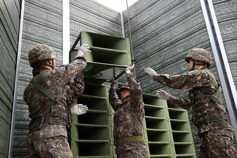 South Korean soldiers taking down a propaganda loudspeaker on the border with North Korea yesterday.