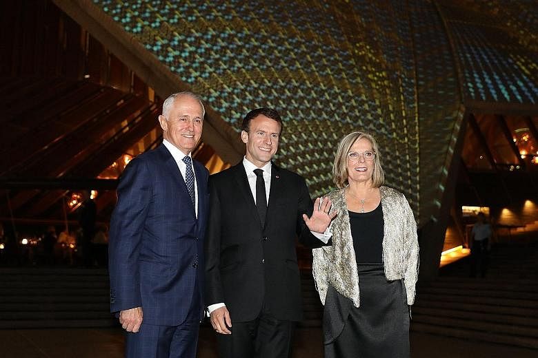 France's President Emmanuel Macron flanked by Australia's Prime Minister Malcolm Turnbull and his wife Lucy outside the Sydney Opera House yesterday.