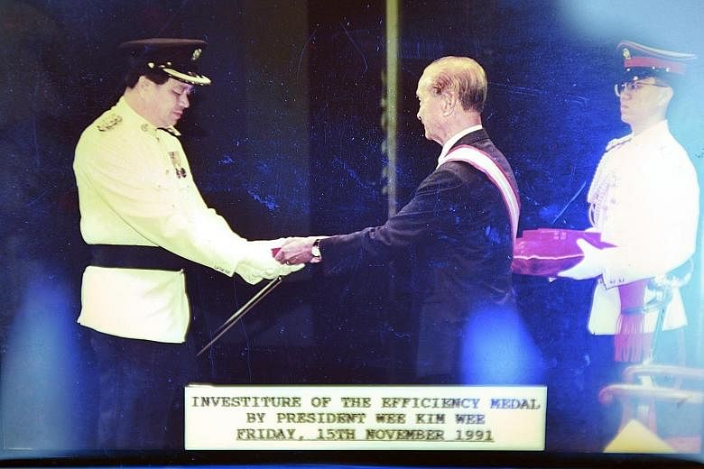 Mr Lee Swee Thin retired as a police superintendent in 2004 but was rehired as a consultant. In 2012, he decided to set up a firm to train government officials on investigation methods. (Top) Mr Lee with two commendation certificates that he received