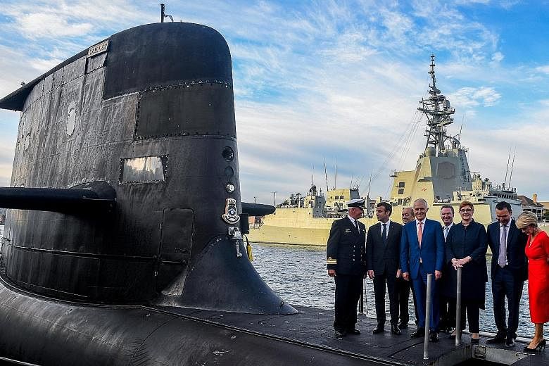 Visiting French President Emmanuel Macron (second from left), with Australian Prime Minister Malcolm Turnbull (centre) and some members of his Cabinet on the submarine HMAS Waller at Garden Island, Sydney, yesterday.