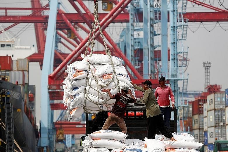 Workers unloading bags of rice from a cargo ship onto a truck at Tanjung Priok Port in Jakarta. The Asean+3 Macroeconomic Research Office said in its report that stronger global growth has helped the region build up buffers against potential external