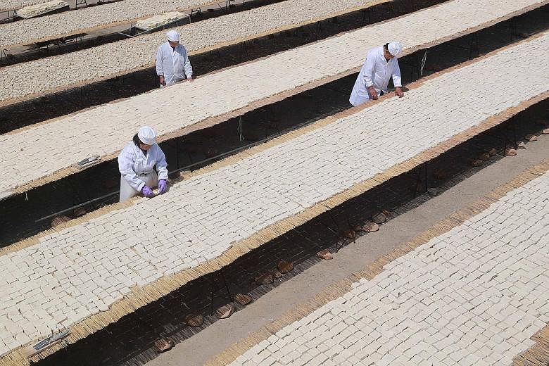 Workers in Qinhuangdao, Hebei, yesterday inspecting tofu. US farmers rely on China as the top buyer of soya beans, the main ingredient of tofu.