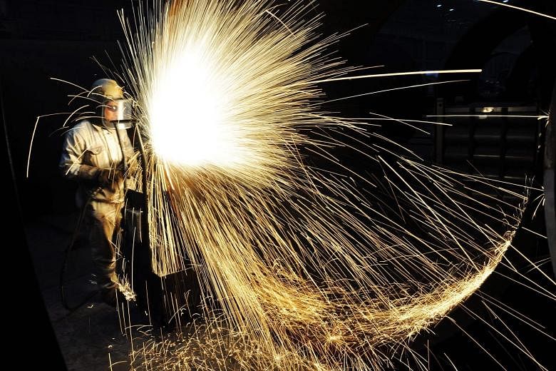 A worker cutting steel in Qingdao on Jan 17. China opened iron ore futures to foreigners in a bid to boost its pricing clout.