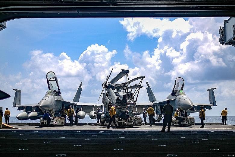 US fighter jets being readied to blast off from an aircraft carrier and later make their way back safely in a series of "arrested landings". For many in the region, says the writer, the hope is that the US does not end up like its fighter planes on "