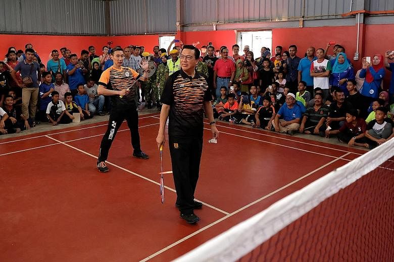 BN candidate for Bentong Liow Tiong Lai (foreground) with badminton star Lee Chong Wei during a friendly match in Bentong on Wednesday.