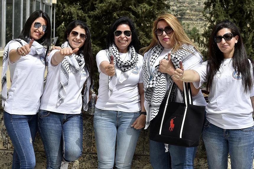 Voters showing off their ink-stained thumbs yesterday after casting their ballots in the town of Moukhtara, at Chouf District in Mount Lebanon. Under the power-sharing agreement, Lebanon's prime minister must be a Sunni Muslim, the president a Maroni