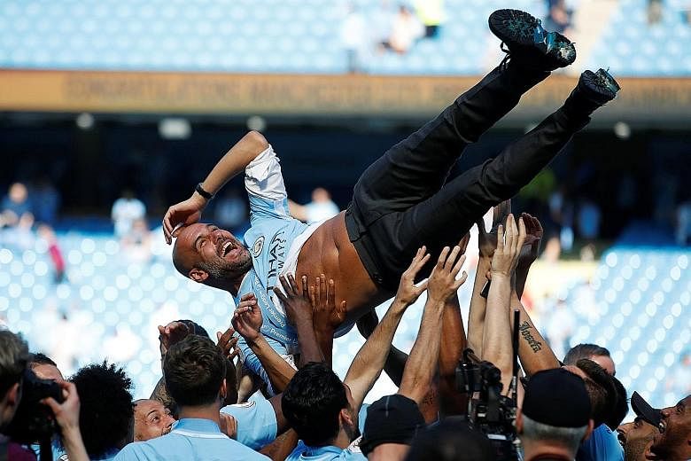 Manchester City manager Pep Guardiola being thrown into the air by his players after they were presented with the Premier League trophy at the Etihad Stadium, following a goalless draw with Huddersfield yesterday.