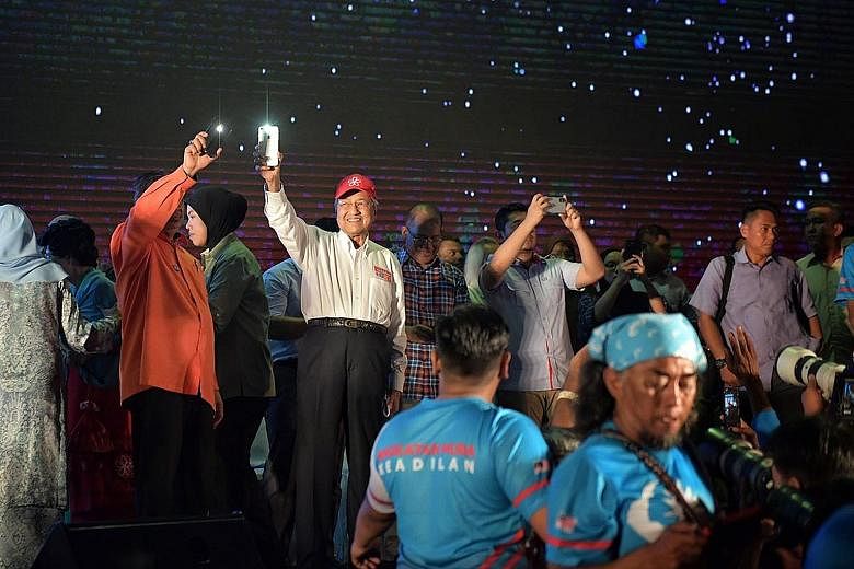 Left: Tun Dr Mahathir Mohamad acknowledging the crowd of supporters at the mega "ceramah" or rally in Hulu Kelang, Selangor, yesterday. Right: Prime Minister Najib Razak greeting supporters during his campaigning in his constituency Pekan, in Pahang,