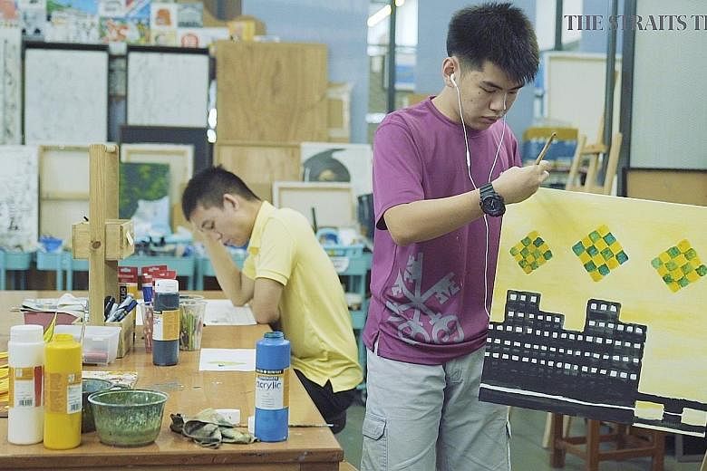 Artists Ezra Chan (far right) and Glenn Phua at work at Pathlight School last month. The two young men with autism, featured in the first episode of the second season of Heroes Among Us, have won acclaim with their artworks.