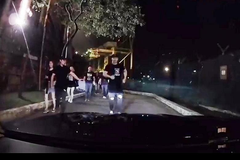 Video screen grabs showing Chee Chu Siong (far right) allegedly running to the car, jumping onto it and stomping his feet on the windscreen.