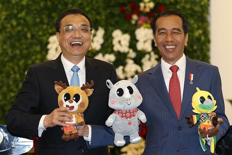 Chinese Premier Li Keqiang and Indonesian President Joko Widodo sharing a light-hearted moment as they hold up the mascots of the 2018 Asian Games during a meeting at Istana Bogor in West Java yesterday. The talks included discussions on regional sec