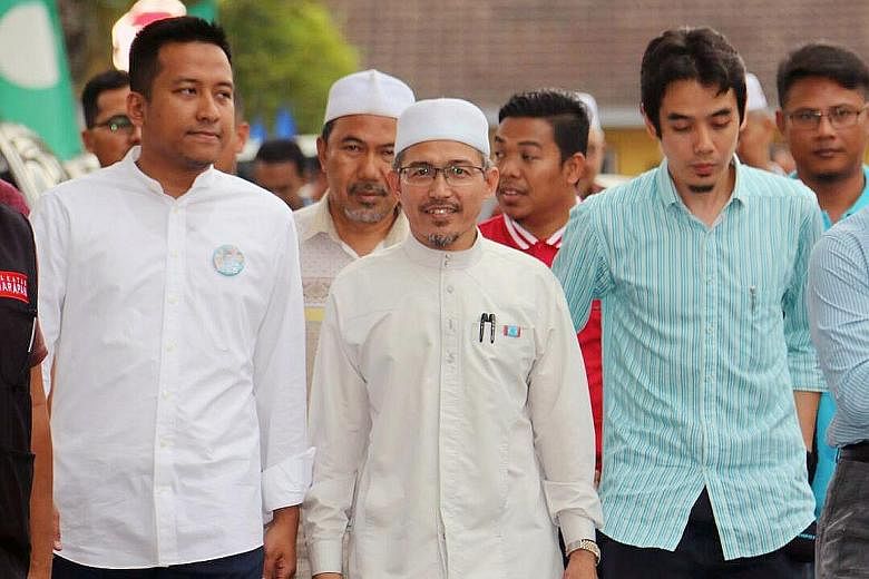 Mr Nik Omar (centre), eldest son of late PAS leader Nik Aziz Nik Mat, on the campaign trail in Shah Alam, Selangor. He has come under fire from his mother and a brother for contesting under the opposition PH banner.