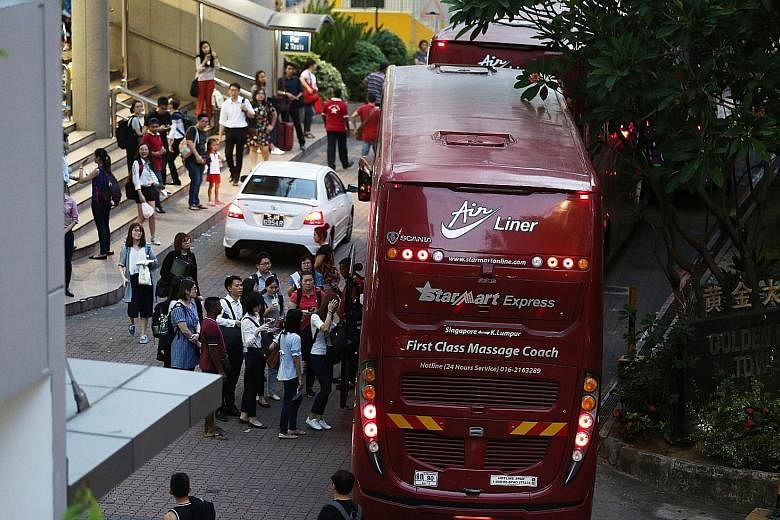 Singapore-based Malaysians boarding coaches at Golden Mile Complex yesterday for the journey home to cast their votes today.