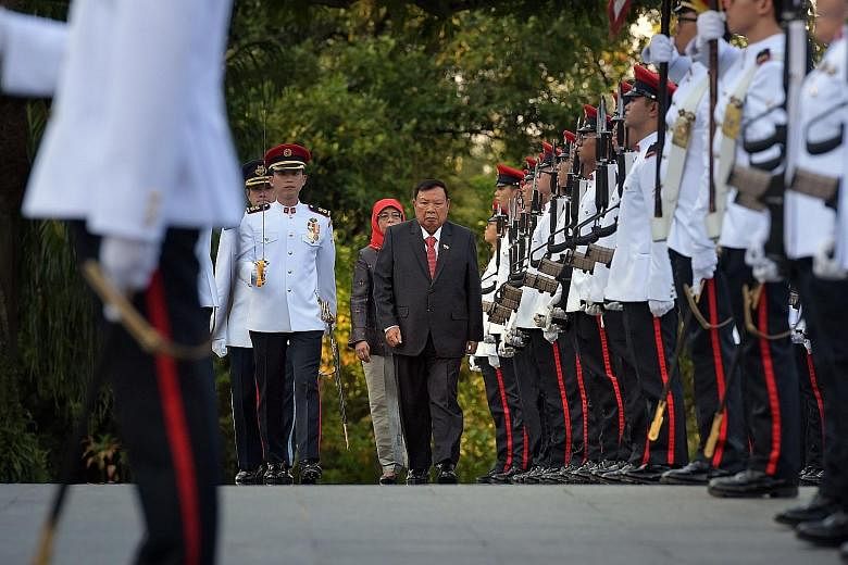 Laos President Bounnhang Vorachith inspecting the guard of honour with President Halimah Yacob at the Istana yesterday. As part of the state visit, President Halimah held a welcome ceremony and state banquet at the Istana in President Bounnhang's hon