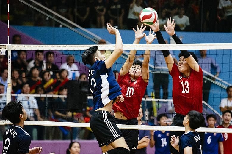 ACJC players Jevvon Tan (middle) and Caleb Seah attempting to block a ball from NYJC's Javier Lee. Nanyang won yesterday's A Division best-of-five final 3-1.