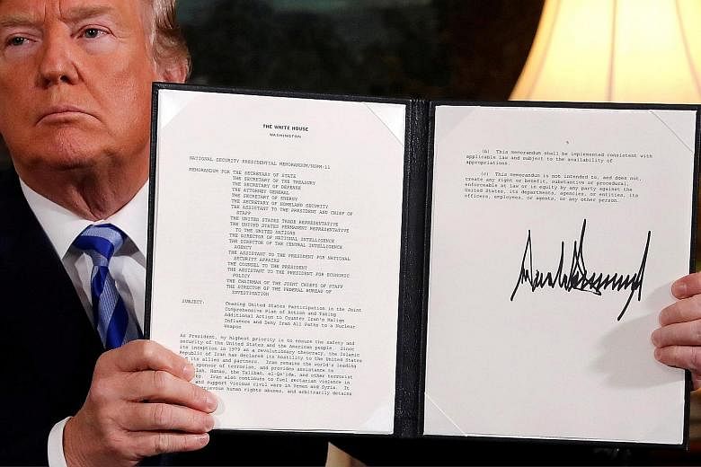 US President Donald Trump holding up the proclamation declaring his intention to withdraw from the Iran nuclear agreement after signing it in the Diplomatic Room at the White House in Washington on Tuesday. His deecision is sure to exacerbate Iran's 