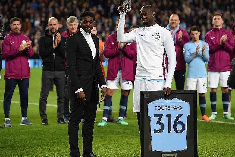 Manchester City's Ivorian midfielder Yaya Toure holds up a memento presented to him by his brother Kolo after the 3-1 win against Brighton on Wednesday.