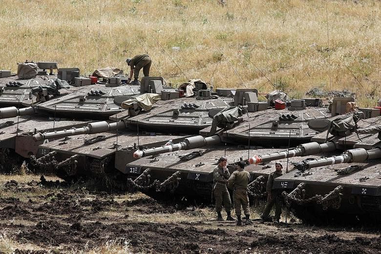Israeli tanks seen near the Syrian border in the Israel-annexed Golan Heights yesterday. Israel's army said it had carried out raids against Iranian targets in Syria overnight after rocket fire towards its forces that it blamed on Iran.