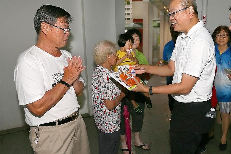 Mr Kok Choy Sing (left), a 68-year-old retiree, received bamboo pole covers and insect repellent from MP Yee Chia Hsing last night at the void deck of Block 953 Jurong West Street 91.