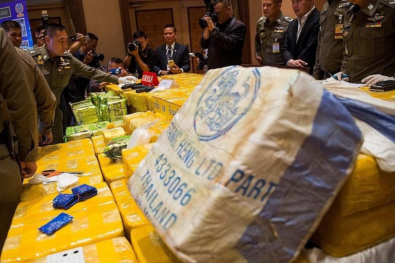 National police chief Chaktip Chaijinda (second from left) inspecting seized drugs and guns during a press conference in Bangkok yesterday.