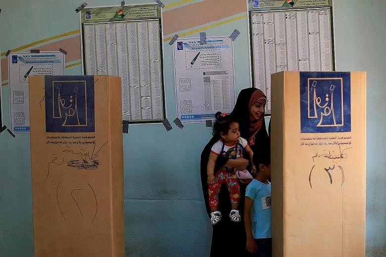 An Iraqi woman voting at a polling station in the Sadr city district of Baghdad yesterday. The winner of the election will have to deal with geopolitics, sectarian divisions, economic hardship and corruption in the country.