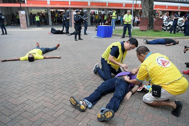 Members of the Singapore Police Force's Clementi Division Emergency Response Team taking down a "terrorist" at Telok Blangah Emergency Preparedness Day yesterday. More than 1,000 residents of Telok Blangah attended the event, which is part of the SGS