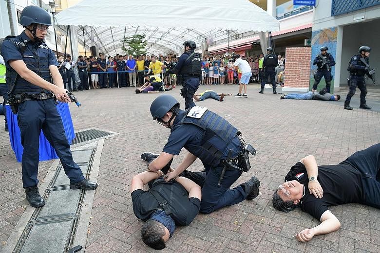 Members of the Singapore Police Force's Clementi Division Emergency Response Team taking down a "terrorist" at Telok Blangah Emergency Preparedness Day yesterday. More than 1,000 residents of Telok Blangah attended the event, which is part of the SGS