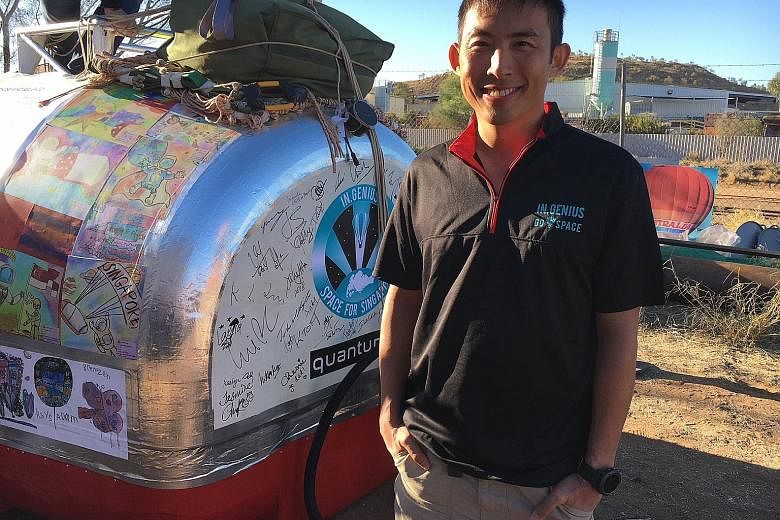 Singaporean air force pilot Yip Chuang Syn with the launch capsule in Alice Springs, Australia, yesterday.