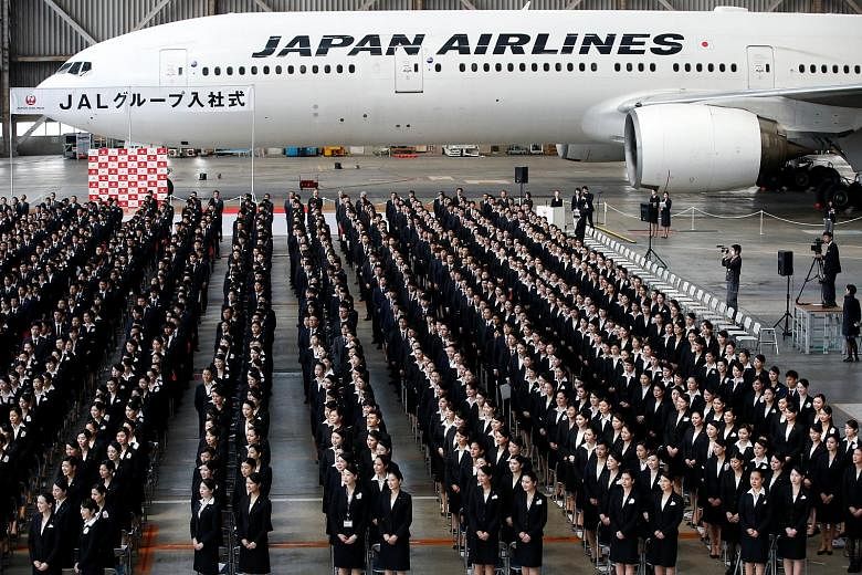 Newly hired employees of Japan Airlines at the group's initiation ceremony in a hangar of Haneda Airport in Tokyo last month. The group is eyeing a larger slice of the budget air travel market, which has been slow to take off in Japan relative to oth