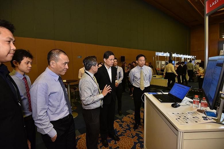 A*Star chairman Lim Chuan Poh (left), Trade and Industry Minister Chan Chun Sing (in jacket) and Enterprise Singapore chief executive Png Cheong Boon (right) viewing exhibits at the SME Technology and Innovation Day yesterday. Mr Chan said more than 