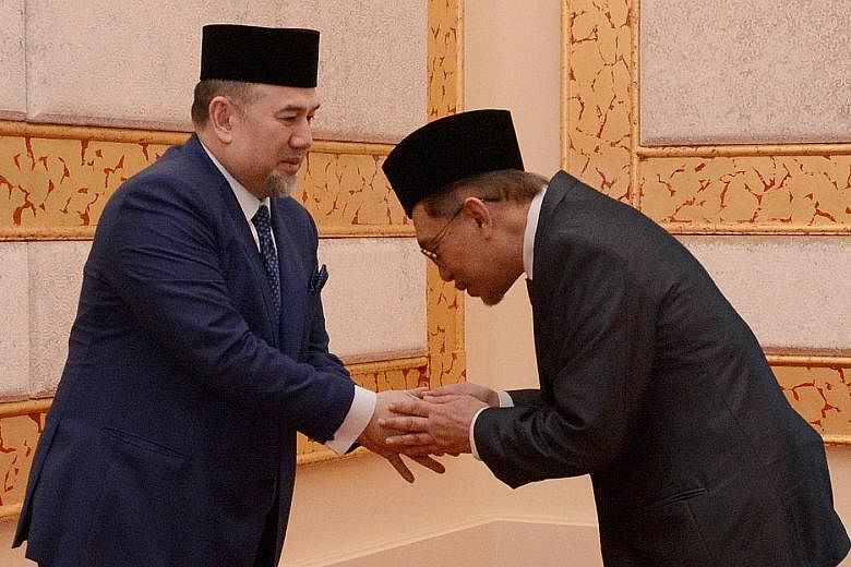 Mr Anwar Ibrahim meeting Malaysia's King, Sultan Muhammad V, at Istana Negara in Kuala Lumpur yesterday after receiving a royal pardon.