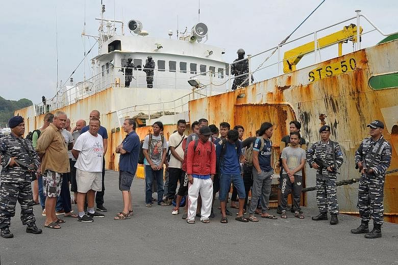 Indonesian navy personnel guarding the detained crew of the stateless STS-50 fishing boat in Sabang, Indonesia, on April 7. Its mostly-Indonesian crew said they had not been paid and that their passports and other documents had been taken away when t