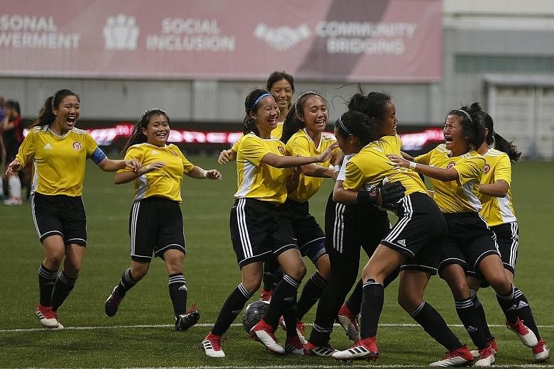 Victoria JC players mobbing goalkeeper Insyirah Maritz after their 4-3 win on penalties against Hwa Chong Institution in the A Division girls' football final yesterday.